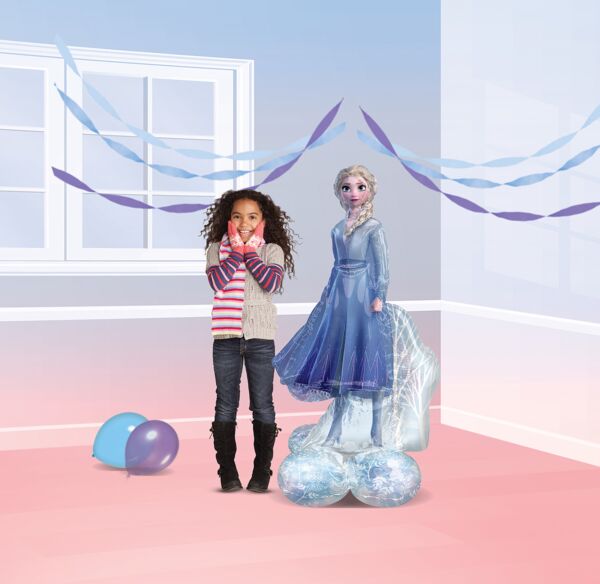 "Children next to large Elsa balloon decoration at Frozen-themed party"