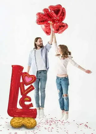 Couple posing with giant LOVE balloon – Valentine’s photo prop