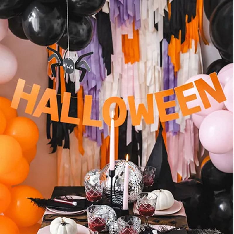 DIY orange garland hanging in spooky party setup