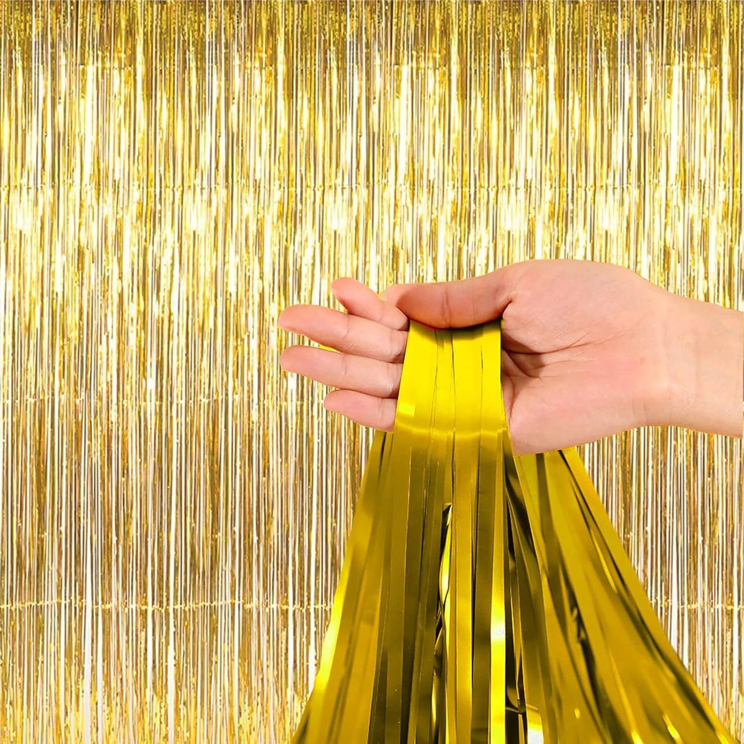 “Hand holding gold foil fringe strands decoration”
