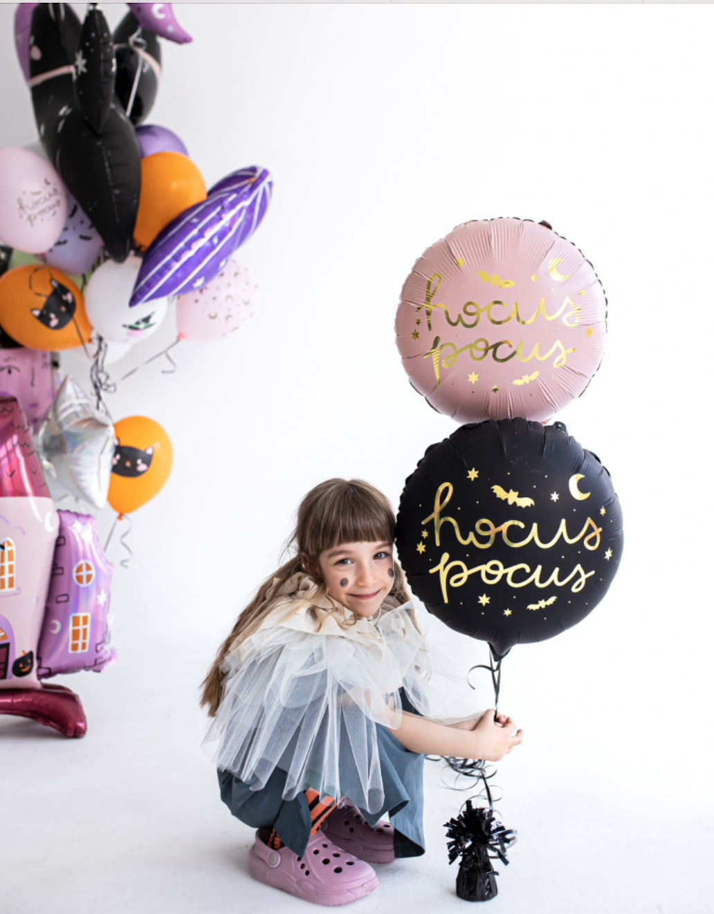 "Girl with Halloween witch decor and Hocus Pocus balloon"