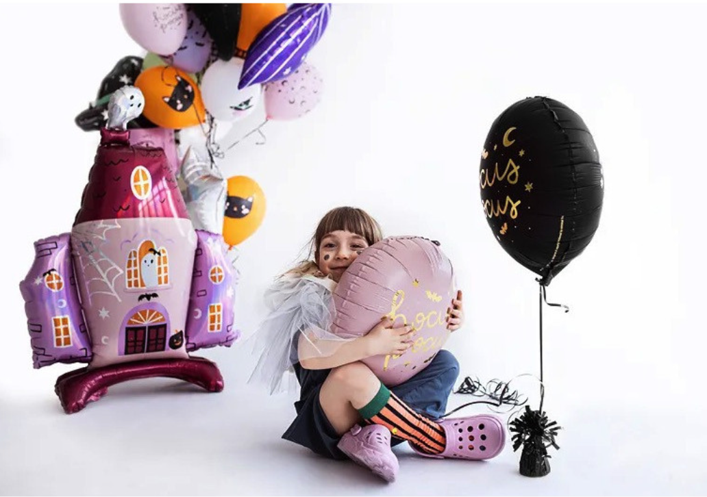"Witch-themed party setup with black and pink Hocus Pocus balloons"