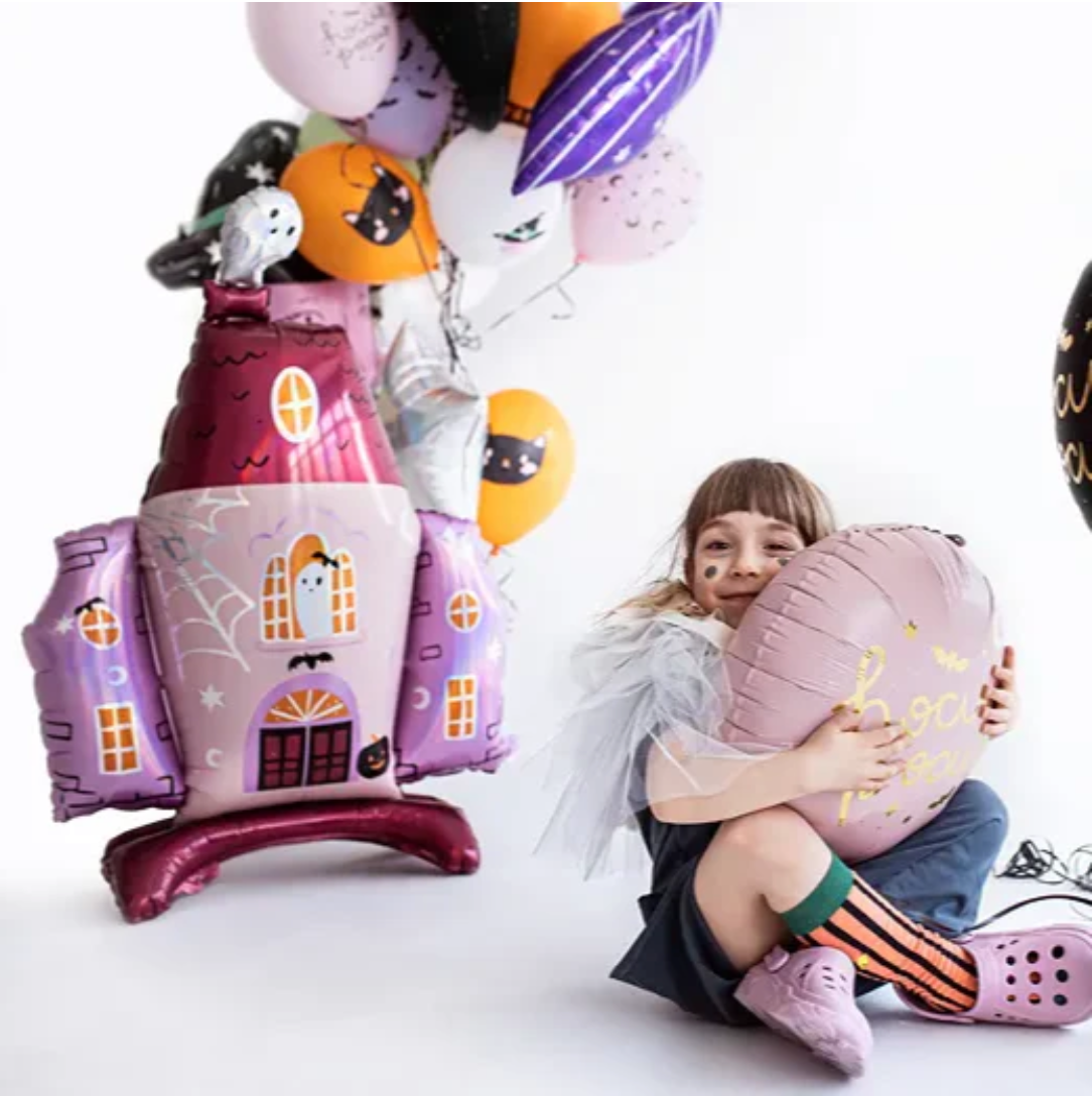 "Child with large haunted house Halloween balloon"