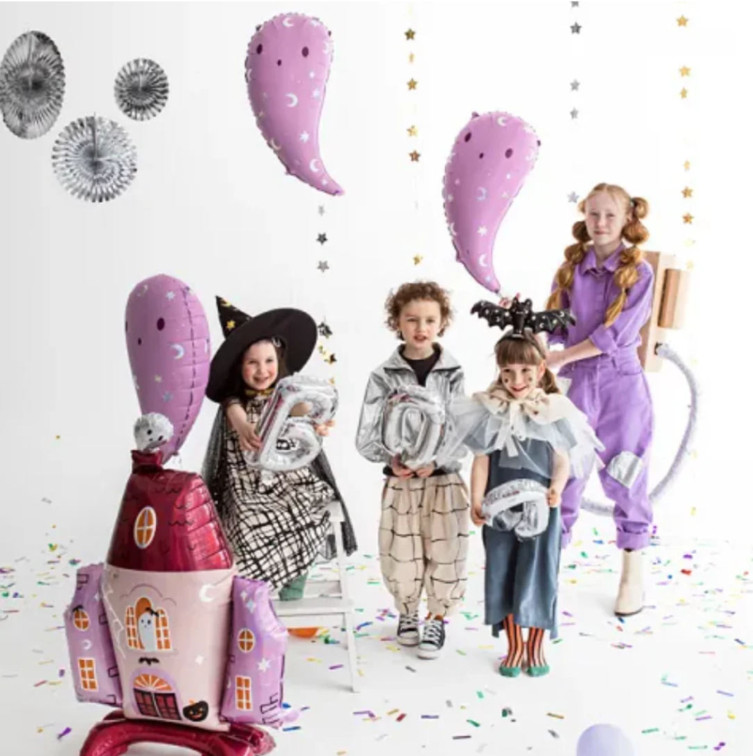 "Halloween party setup with haunted house balloon and kids in costumes"