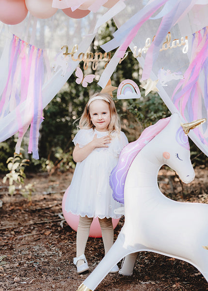 Standing foil unicorn balloon with golden horn and pastel mane for parties