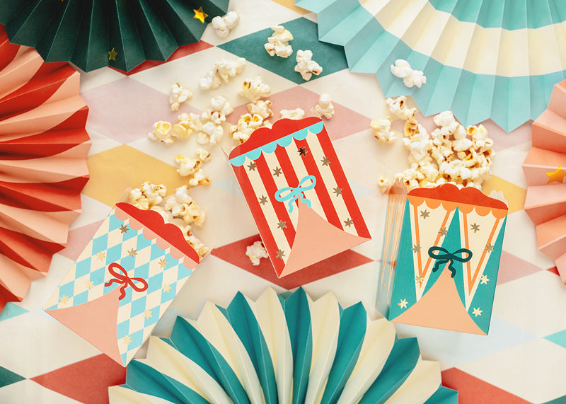 Flat lay of circus boxes surrounded by paper fans and decorations