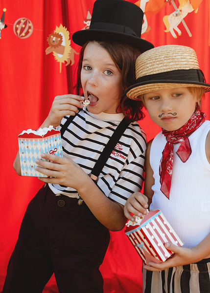 Parent and child dressed as circus performers with snack boxes

